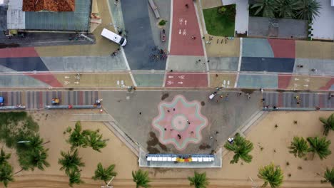 Rising-bird's-eye-top-view-of-the-center-plaza-at-the-touristic-Tambaú-beach-boardwalk-in-the-tropical-beach-city-of-Joao-Pessoa,-Paraiba,-Brazil-with-people-gathering-for-pictures-at-the-sign