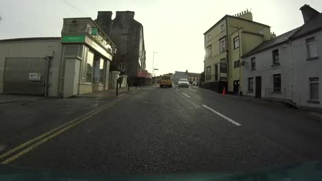 Timelapse-from-a-car-moving-through-the-city-of-Gort-in-Ireland,-city-and-cars-driving-on-a-cloudy-day