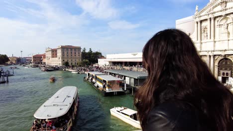Mujer-Viajera-En-El-Famoso-Puente-De-Rialto-Sobre-El-Gran-Canal-Con-Vaporetto-Navegando-En-Venecia,-Italia