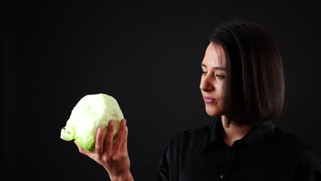 Young-Woman-Holding-and-Looking-at-Cabbage,-Vegan-and-Healthy-Diet-Concept