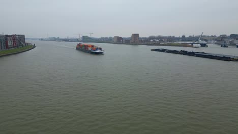 Luftflug-Auf-Das-Sich-Nähernde-Containerschiff-Scaldis,-Das-An-Einem-Bewölkten-Tag-In-Dordrecht-Entlang-Der-Oude-Maas-Fährt
