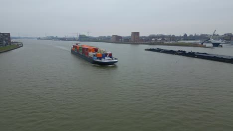 Vista-Aérea-De-Un-Dron-Del-Buque-Portacontenedores-Scaldis-Que-Se-Aproxima-Viajando-A-Lo-Largo-De-Oude-Maas-En-Un-Día-Nublado-En-Dordrecht