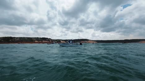 Schwenk-Action-Kamera,-Aufgenommen-Auf-Einem-Kleinen-Fischerboot,-Das-An-Angedockten-Booten-Am-Cacimba-Strand-In-Der-Berühmten-Surfstrandstadt-Baia-Formosa-In-Rio-Grande-Do-Norte,-Brasilien,-An-Einem-Sommertag-Vorbeisegelt