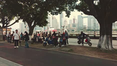 Gente-Estacionando-Motos-En-El-Parque-Junto-Al-Río-En-Guangzhou,-China