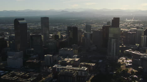 Drone-dolley-shot-of-high-modern-buildings-in-Denver-with-high-mountains-at-the-horizon
