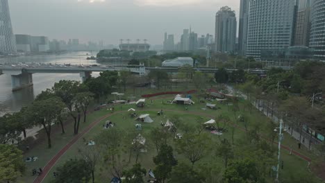 Personas-Acampando-Afuera-En-El-Parque-Lineal-Linjiang-Junto-Al-Río-Zhujian-En-Guangzhou,-China