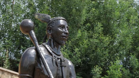 Mittlere-Nahaufnahme:-Bronzestatue-Des-Königs-Moshoeshoe-Mit-Vom-Wind-Wehenden-Bäumen