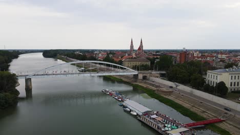Aerial-view-flying-towards-Votive-Church,-Szeged,-Hungary,-over-Tisza-River