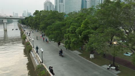 Tourists-riding-bikes-and-and-walking-on-road-by-the-Linjiang-Linear-Park-in-Guangzhou,-China