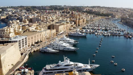 Marina-Bay,-Yachts-And-Boats-In-Birgu-City,-Malta---aerial-drone-shot