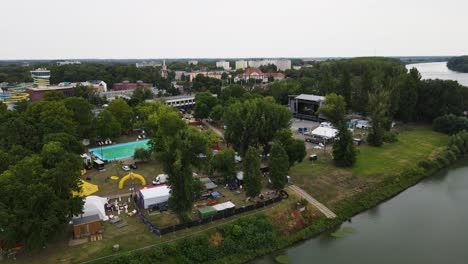 Aerial-tracking-over-site-of-SZIN-Festival-in-Szeged,-Hungary-by-Tisza-River