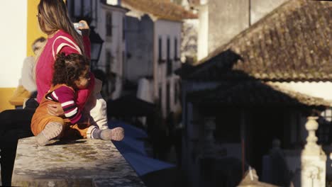 Mom-holding-daughter-or-child-and-taking-selfie-photo-in-town,-city-life-concept