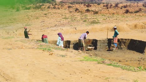 Local-group-of-workers-digging-clay-material-for-making-bricks-in-rural-Bangladesh