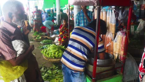 Ein-Eisverkäufer-Verkauft-Gefrorene-Leckereien-Auf-Einem-Belebten-Asiatischen-Gemüsemarkt