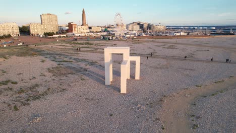 Vista-Aérea-De-Gente-Caminando-En-La-Playa-Cerca-De-Los-500-Años-De-La-Escultura-Monumental-De-Le-Havre-En-Francia