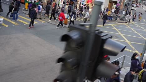 This-is-a-drive-by-shot-from-a-tram,-viewing-cars-driving,-traffic-lights-and-people-walking-in-Hong-Kong-city