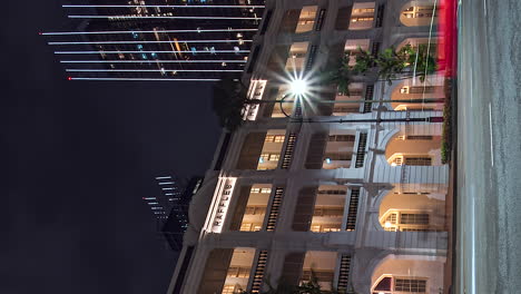 Vertical-format-timelapse-of-traffic-driving-past-Raffles-Hotel,-Singapore