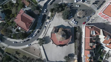 aerial-orbit-and-cinematic-soaring-view-of-historical-Santo-Amaro-chapel-surrounded-by-mosaic-floor,-Portugal