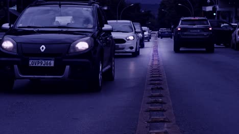 Traffic-driving-on-road-in-slow-motion-in-Brazil,-blue-tint-filter-effect