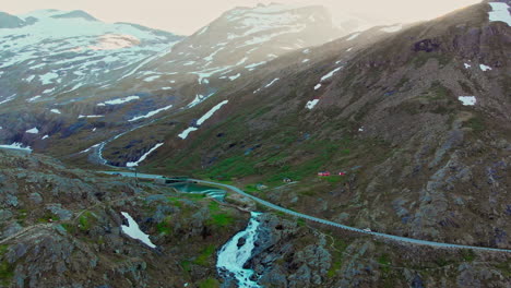 Tracking-shot-of-a-car-driving-through-the-Trollstigen-with-waterfalls-in-the-foreground