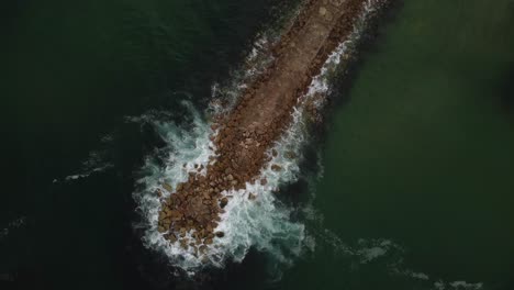 Breakwater-Jetty-Protecting-Coastline-from-Ocean-Waves---Aerial-Drone-Top-Down-Rotating-View