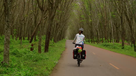 Woman-cycles-along-southeast-asia-tropical-jungle-bikepath-in-koh-samui
