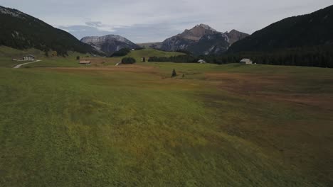 Drone-flying-over-green-meadow-of-Plateau-des-Glières-in-Haute-Savoie,-France