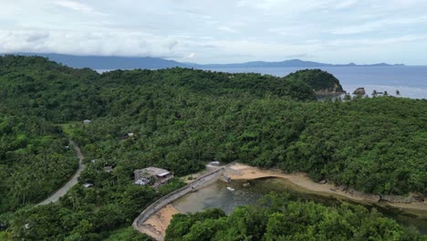 Overhead-drone-shot-of-Mountainous-Island-with-Lush-Greenery-and-idyllic-Sea-cove-in-Virac,-Catanduanes