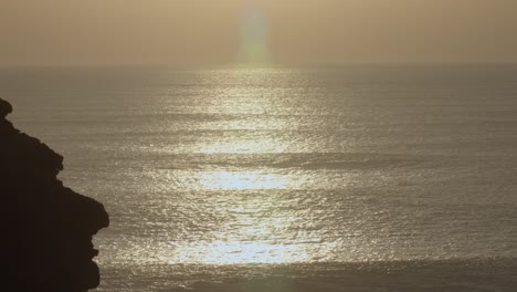Spiegelungen-Des-Sonnenuntergangs-über-Dem-Wasser-Am-Nordstrand-Von-Nazaré-In-Portugal