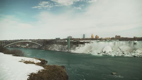 Niagara-Falls-and-the-Rainbow-Bridge-in-snowy-winter,-wide-static-view