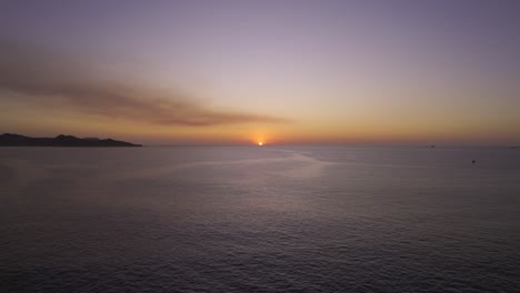 Drohnenflug-über-Ruhiges-Meer-Mit-Sonnenuntergang-Am-Horizont,-4k