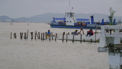 Transbordador-Dando-La-Vuelta-Con-Gente-Relajándose-En-El-Muelle-En-Frente,-Ferry-De-Songkhla,-Tailandia