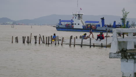 Fähre-Dreht-Sich-Um-Und-Menschen-Entspannen-Sich-Am-Pier-Davor,-Songkhla-Fähre,-Thailand