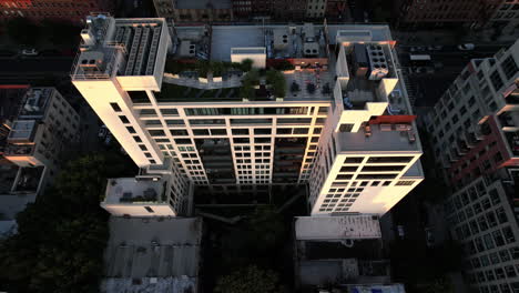 Aerial-view-of-the-rooftop-and-sunlit-side-of-a-modern-apartment,-in-Brooklyn,-NY,-USA---reverse,-tilt,-drone-shot