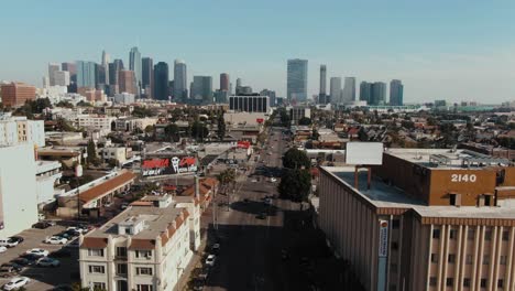 Drone-flyover-Los-Angeles-Streets-with-the-skyscrapers-in-the-distance,-Pullback-shot