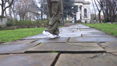 Low-ground-view-of-feet-of-young-woman-dancing-modern-freestyle-hip-hop-dance-outside-on-sidewalk