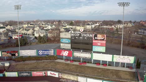 McCoy-Stadium-in-Pawtucket-Rhode-Island,-wide-rotating-drone-of-abandoned-baseball-field-scoreboard,-aerial