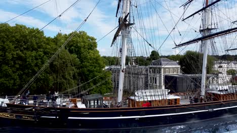 Toma-Aérea-Del-Barco-Cutty-Sark-Y-Su-Mástil,-Turistas-En-El-Barco,-Londres,-Reino-Unido