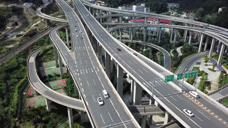 Aerial-shot-of-circular-roads-and-highways-floating-five-levels-exchange-in-Chongqing-and-cars-driving-on-them,-Huangjuewan-exchange