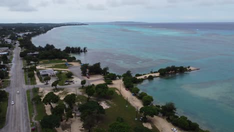 Drone-view-of-Saipan-City-and-turquoise-blue-ocean-with-horizon,-Northern-Mariana-Islands