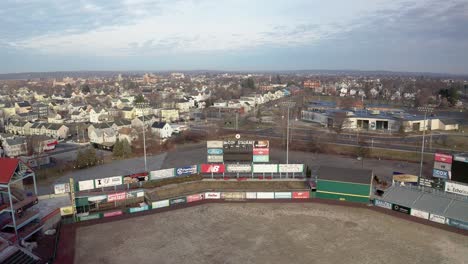 McCoy-Stadium-in-Pawtucket-Rhode-Island,-wide-drone-shot-reveal-abandoned-stadium-and-homes-around-the-baseball-field,-aerial