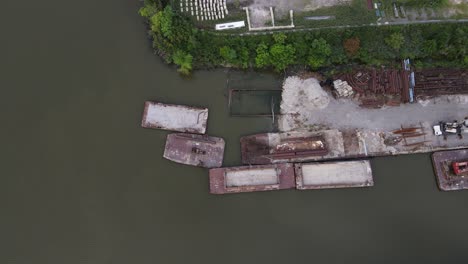 Old-derelict-buildings-and-barges-of-industrial-dock,-aerial-top-down-view