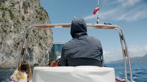 A-traditional-boat-is-sailing-along-Capri's-coast-in-Italy-during-a-sunny-and-col-day-in-spring