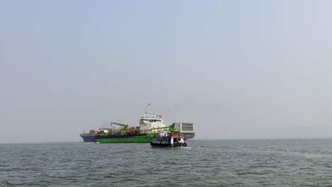 A-shot-of-a-tourist-boat-moving-towards-a-large-ship-in-the-Arabian-sea