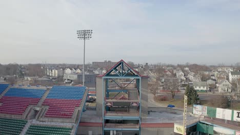 McCoy-Stadium-in-Pawtucket-Rhode-Island,-rising-drone-shot-to-reveal-the-urban-sprawl-around-the-abandoned-stadium,-aerial