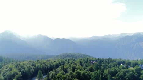Luftdrohnen-Fliegen-über-Den-Europäischen-Julischen-Alpen,-Slowenien,-Grüne-Waldlandschaft-In-Alpiner-Höhe,-Malerische-Himmelssicht-Auf-Den-Vogelberg-Zwischen-Den-Wolken