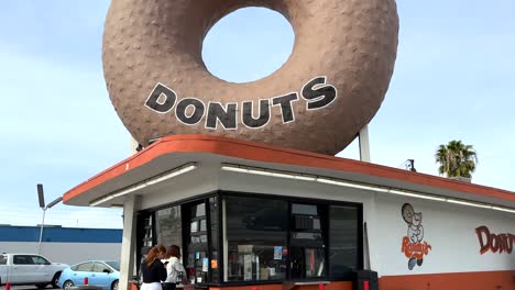 Famosas-Rosquillas-De-Randy-En-Inglewood,-Los-ángeles,-Ee.uu.,-Rosquilla-Gigante-Y-Escaparate-Con-Gente