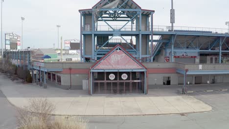 McCoy-Stadium-in-Pawtucket-Rhode-Island,-revealing-drone-starting-on-the-entrance-of-the-abandoned-baseball-field,-aerial