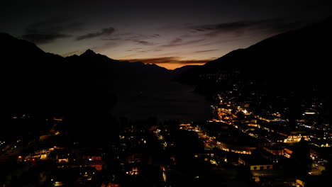Sunset-remains-over-Queenstown-central-at-night,-New-Zealand,-aerial-drone-view