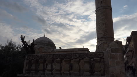 Vom-Unteren-Winkel-Nach-Oben-Sehen-Wir-Im-Gegenlicht-Die-Silhouette-Der-Großen-Moschee-Von-Mardin-Und-Dahinter-Den-Tiefblauen-Himmel-Und-Die-Wolken,-Die-Wie-Baumwolle-Aussehen